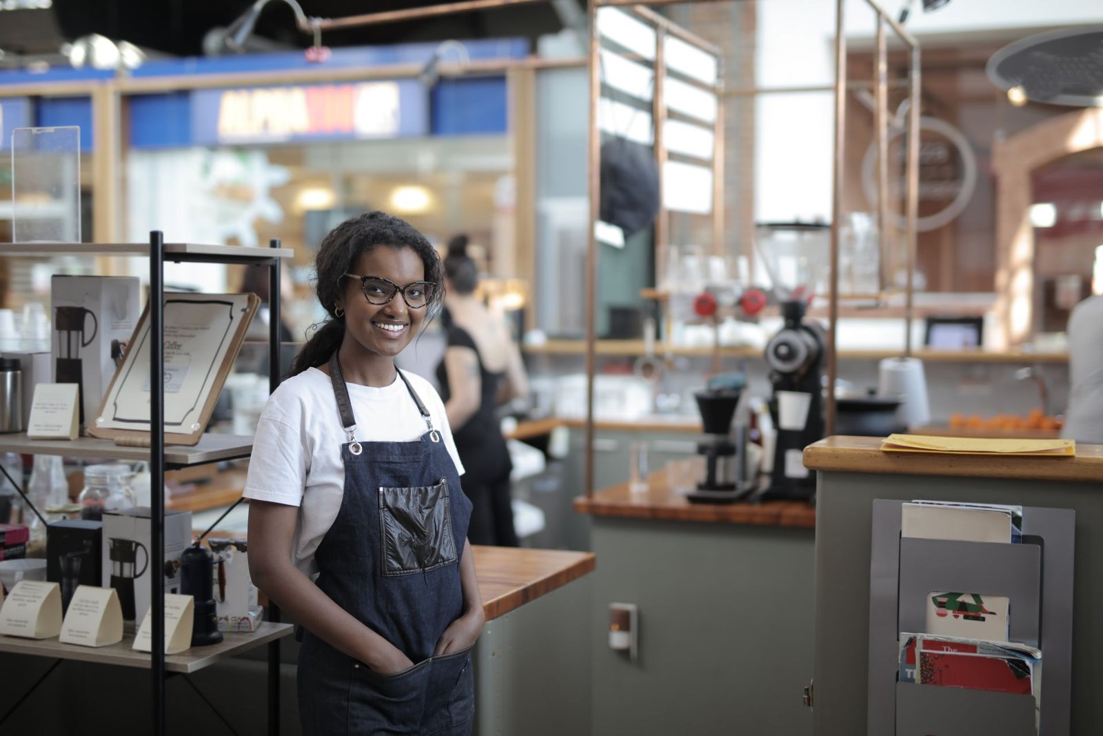 Barista sorrindo em pé no seu café