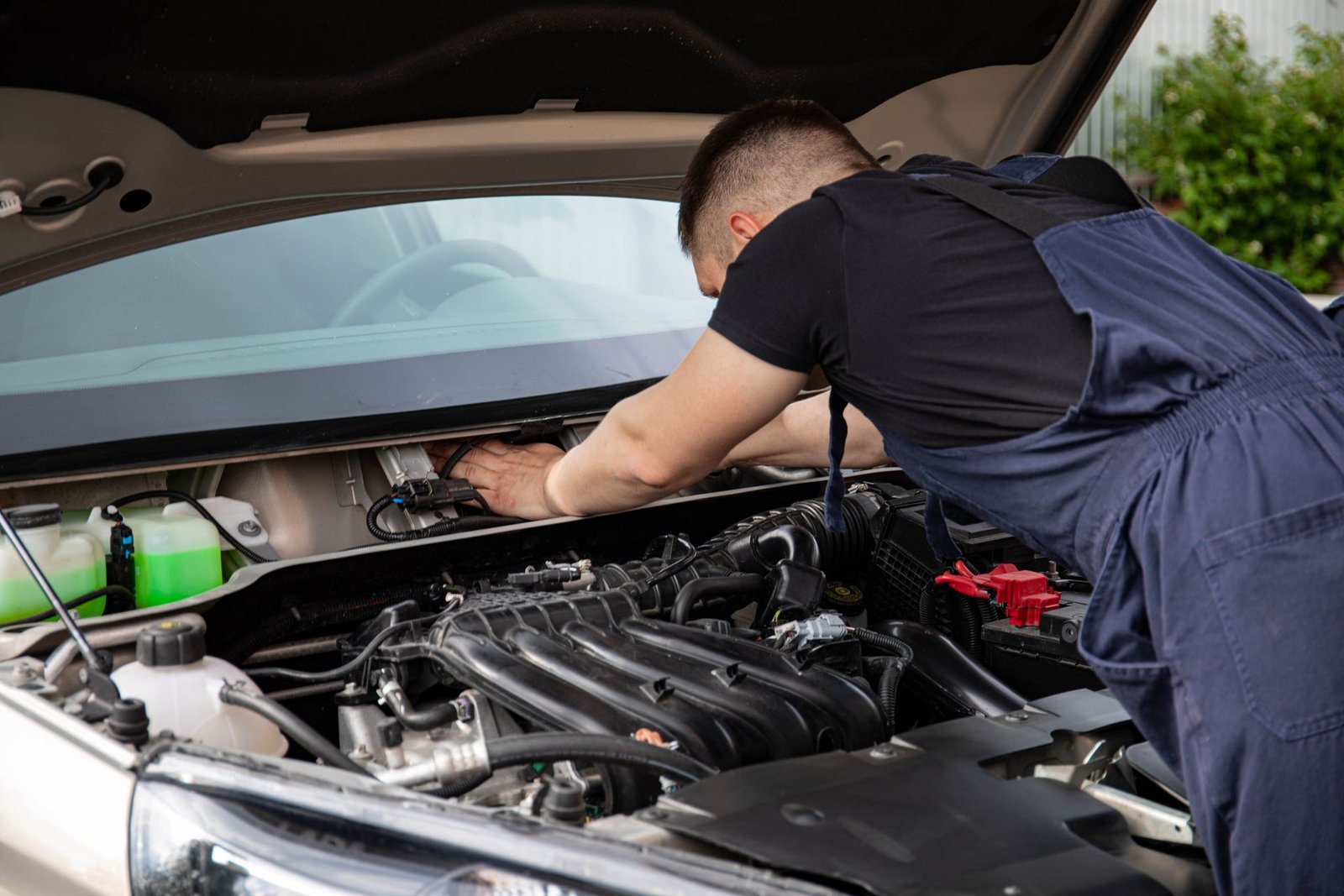 Close das mãos de um mecânico fazendo manutenção no motor