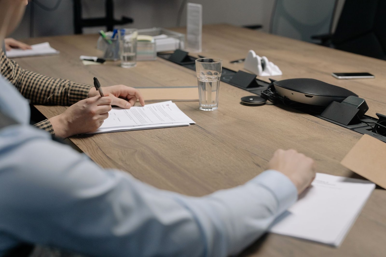 Pessoa assinando um contrato de prestação de serviços sobre a mesa