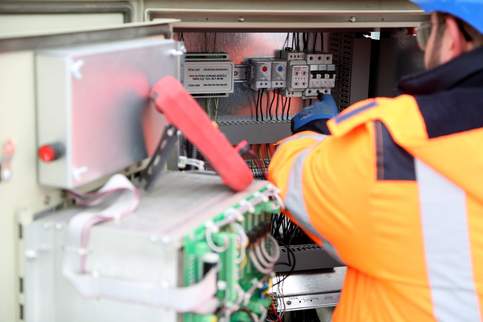 Profissional inspecionando o painel elétrico de um equipamento industrial