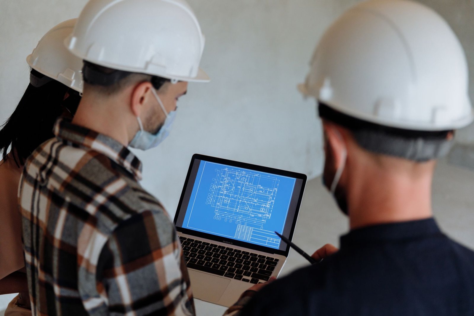 Profissionais de capacete analisando o projeto e o orçamento da obra